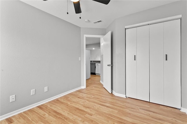1506 W 25th Ct Unit E5, Lawrence, KS 66046 - unfurnished bedroom with light wood-style floors, baseboards, a closet, and a ceiling fan