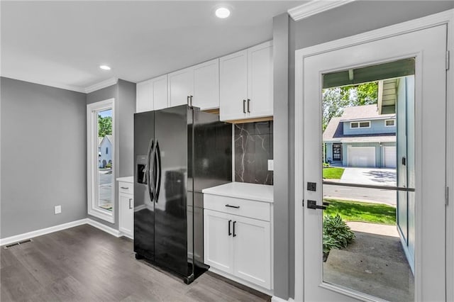 6531 W 49th St, Mission, KS 66202 - kitchen with black refrigerator with ice dispenser, ornamental molding, dark wood-style floors, plenty of natural light, and white cabinets