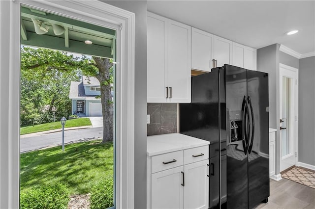 6531 W 49th St, Mission, KS 66202 - kitchen featuring black refrigerator with ice dispenser, white cabinetry, crown molding, tasteful backsplash, and baseboards