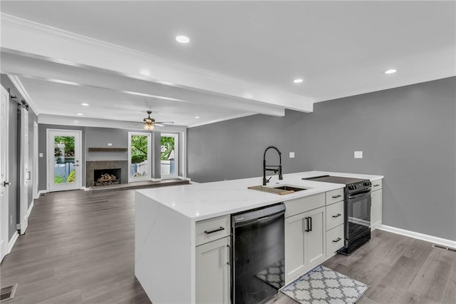 6531 W 49th St, Mission, KS 66202 - kitchen with black appliances, a sink, wood finished floors, a ceiling fan, and white cabinetry