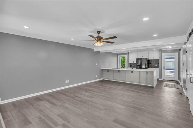 6531 W 49th St, Mission, KS 66202 - unfurnished living room with ornamental molding, baseboards, ceiling fan, recessed lighting, and dark wood-style flooring