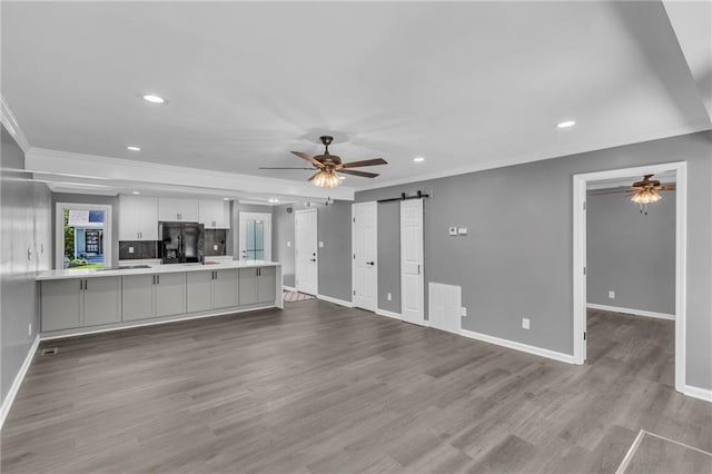 6531 W 49th St, Mission, KS 66202 - unfurnished living room featuring a ceiling fan, a barn door, crown molding, recessed lighting, and baseboards