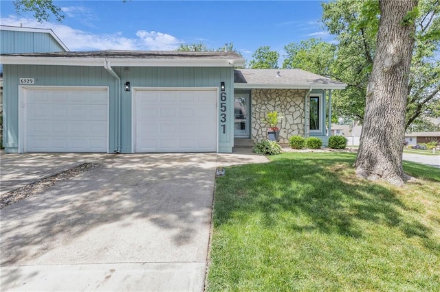 6531 W 49th St, Mission, KS 66202 - view of front facade featuring a garage, driveway, a front yard, and stone siding