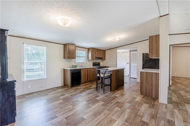 549 N Linn Valley Dr, Linn Valley, KS 66040 - kitchen featuring black appliances, brown cabinetry, light wood finished floors, light countertops, and a textured ceiling