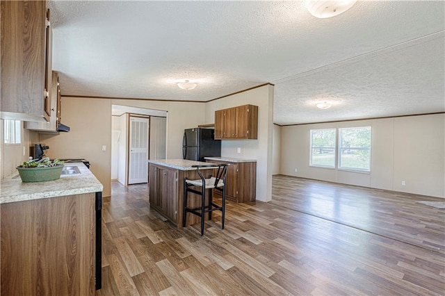 549 N Linn Valley Dr, Linn Valley, KS 66040 - kitchen with freestanding refrigerator, brown cabinets, light wood-style floors, light countertops, and a textured ceiling