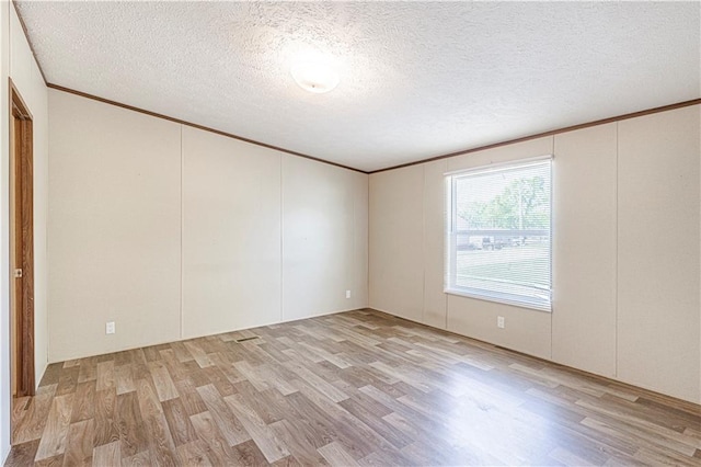 549 N Linn Valley Dr, Linn Valley, KS 66040 - empty room with light wood finished floors, crown molding, a textured ceiling, and a decorative wall