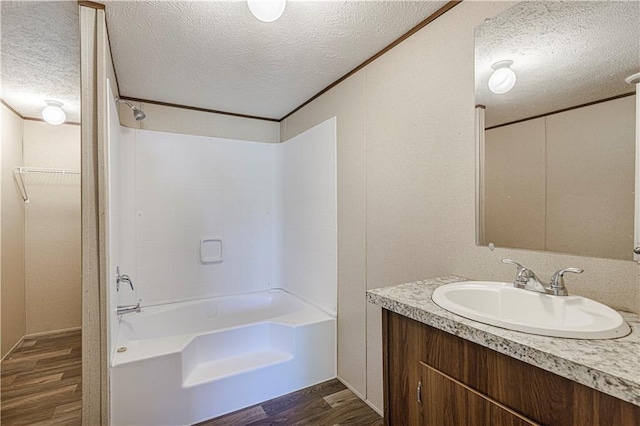 549 N Linn Valley Dr, Linn Valley, KS 66040 - bathroom with a textured ceiling, wood finished floors, vanity, and bathtub / shower combination