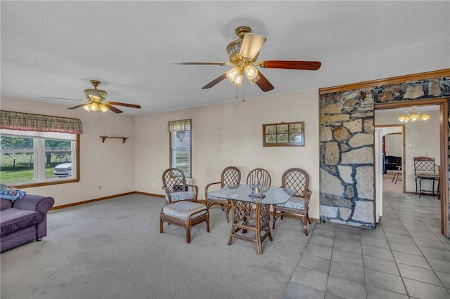 carpeted dining area featuring healthy amount of natural light, ceiling fan, baseboards, and a textured ceiling