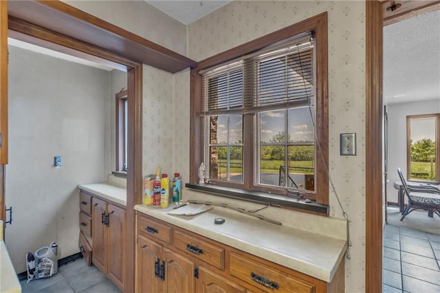bathroom featuring wallpapered walls, tile patterned floors, a textured ceiling, and vanity