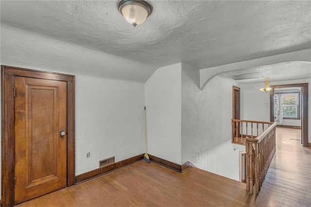 bonus room with wood finished floors, baseboards, and radiator