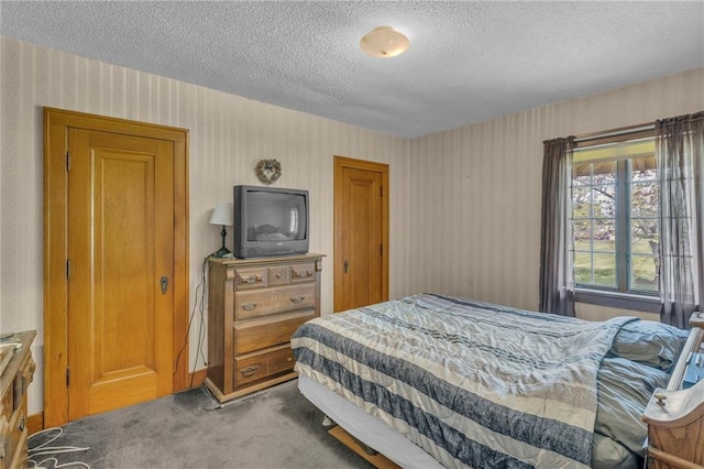 bedroom featuring carpet flooring, wallpapered walls, and a textured ceiling