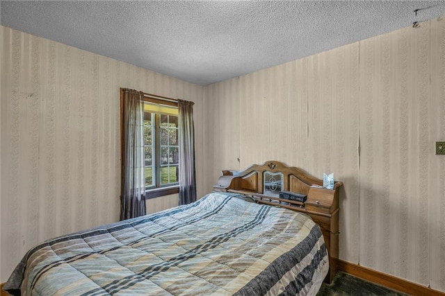 bedroom with a textured ceiling and wallpapered walls