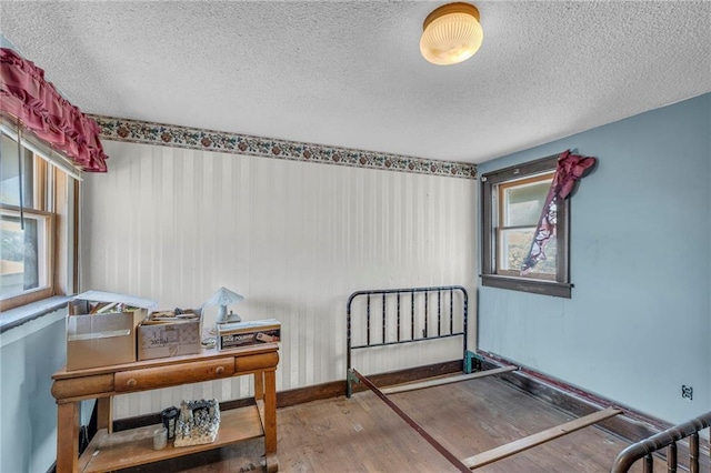 bedroom with wood finished floors and a textured ceiling