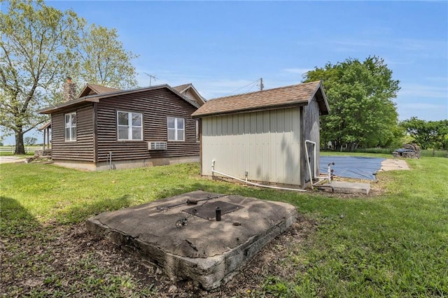 view of side of home featuring a lawn, a chimney, an outdoor structure, a shed, and a fire pit