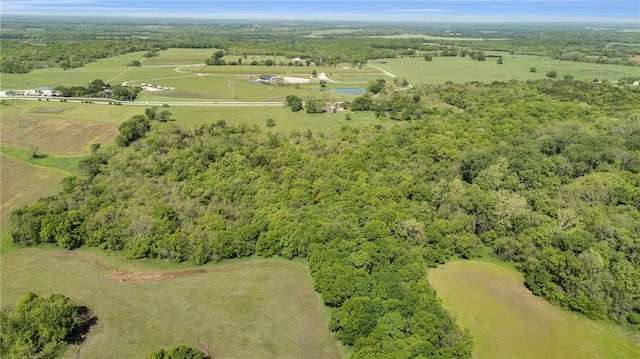 aerial view of property's location with a heavily wooded area and rural landscape