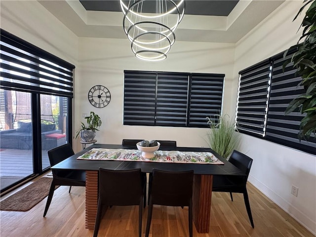 8890 Mccoy St, Lenexa, KS 66227 - dining room featuring a chandelier, wood finished floors, baseboards, and a raised ceiling