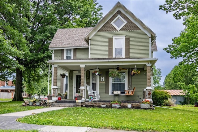 203 S Hughes St, Hamilton, MO 64644 - victorian house featuring covered porch, a front lawn, and ceiling fan