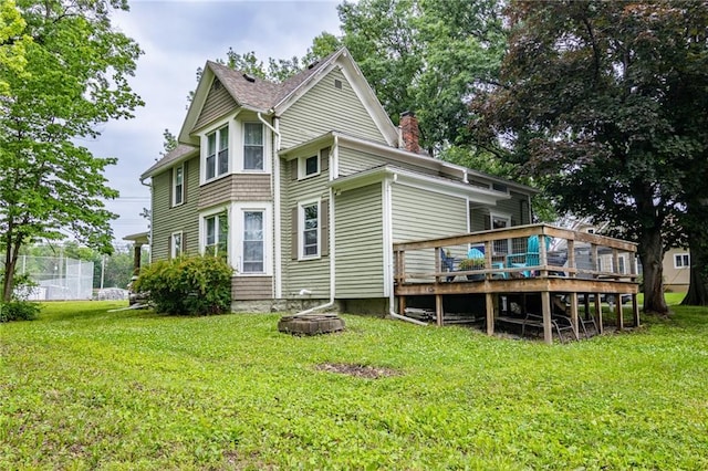 203 S Hughes St, Hamilton, MO 64644 - rear view of house with a chimney, a wooden deck, and a lawn