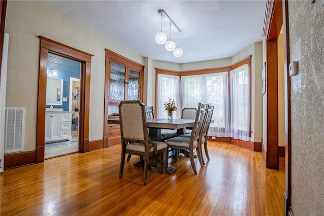 203 S Hughes St, Hamilton, MO 64644 - dining room with light wood-style flooring, track lighting, a textured ceiling, a chandelier, and a textured wall