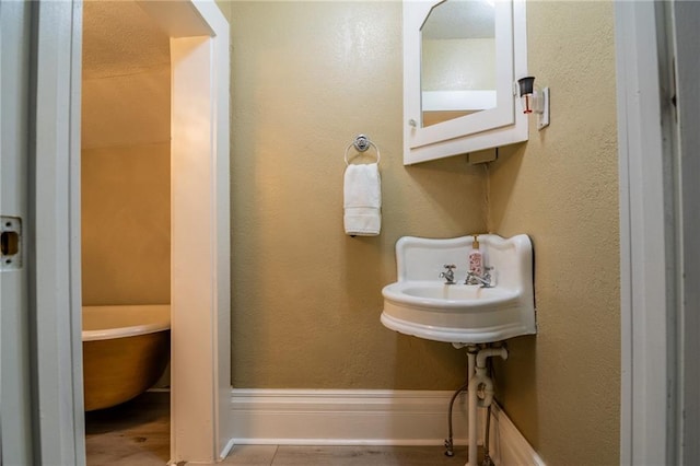 203 S Hughes St, Hamilton, MO 64644 - bathroom featuring baseboards and a freestanding bath