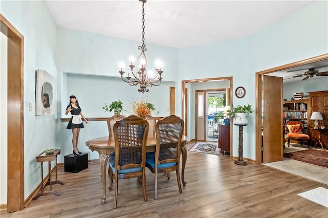dining room featuring a chandelier, wood finished floors, and a ceiling fan