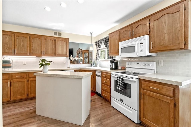 kitchen with white appliances, tasteful backsplash, light countertops, and recessed lighting