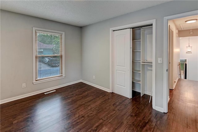 1205 SW 20th St, Blue Springs, MO 64015 - unfurnished bedroom featuring attic access, dark wood-style flooring, baseboards, a closet, and a textured ceiling