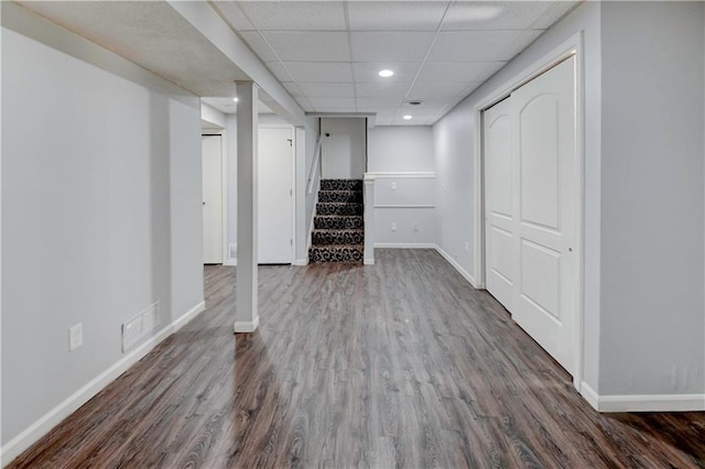 1205 SW 20th St, Blue Springs, MO 64015 - finished basement with stairs, dark wood-type flooring, baseboards, recessed lighting, and a paneled ceiling