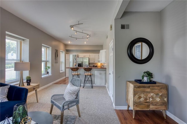living room featuring baseboards, wood finished floors, track lighting, and carpet floors