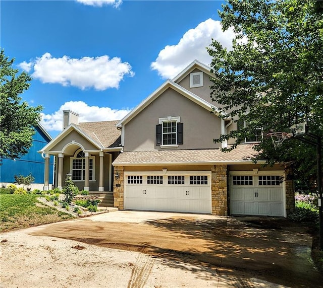 traditional home with stucco siding, stone siding, an attached garage, concrete driveway, and a chimney