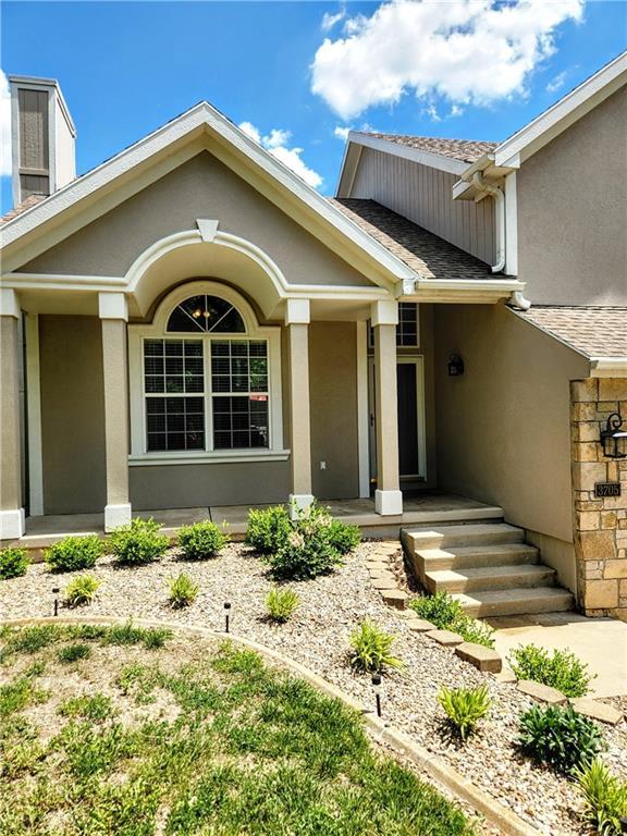 property entrance with stucco siding and a shingled roof