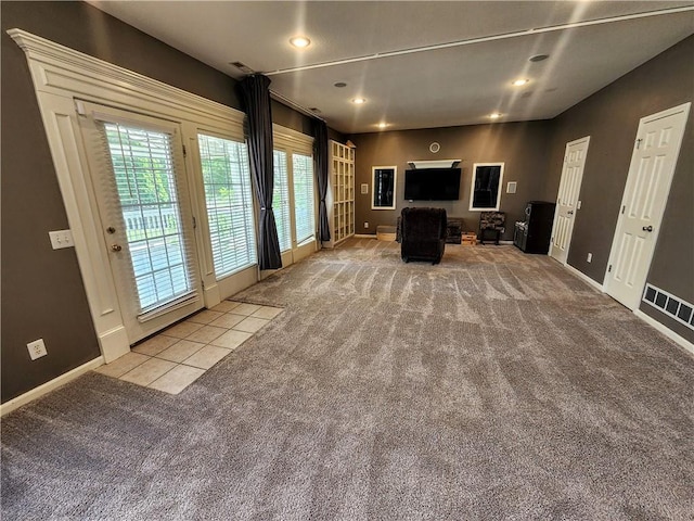unfurnished living room with carpet, baseboards, and recessed lighting