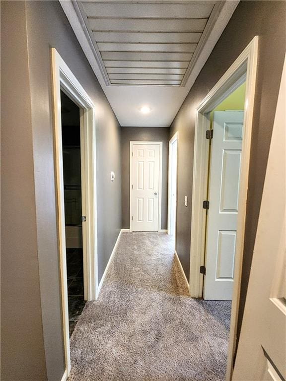 corridor with carpet floors and baseboards