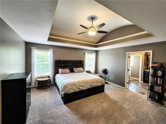 bedroom with lofted ceiling, carpet flooring, baseboards, ornamental molding, and a raised ceiling