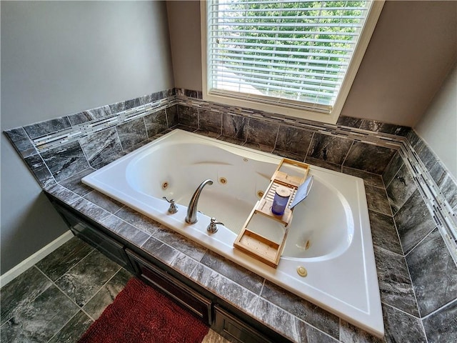 bathroom featuring a jetted tub and baseboards