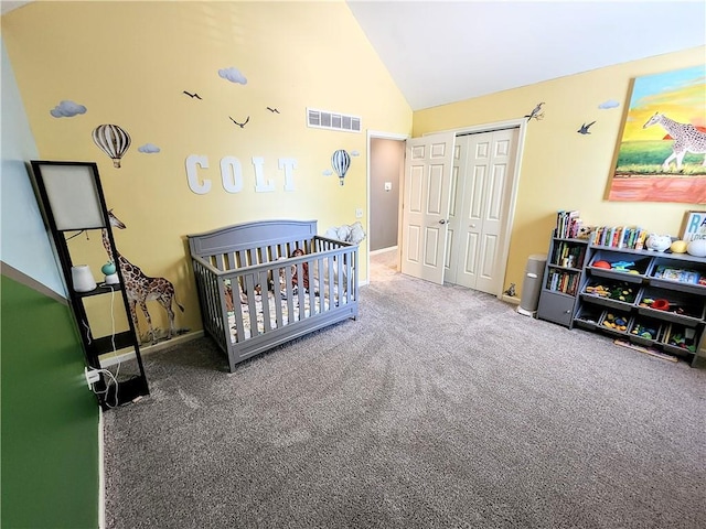 carpeted bedroom featuring vaulted ceiling, a closet, a nursery area, and baseboards