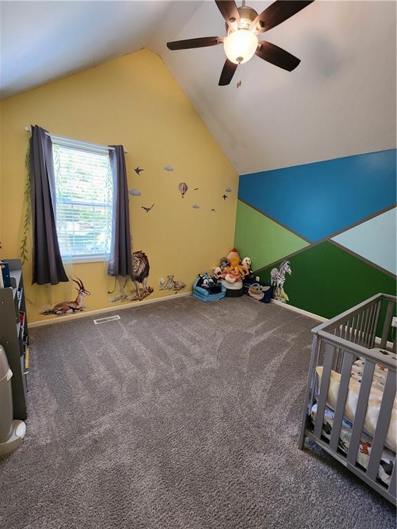 unfurnished bedroom with vaulted ceiling, carpet flooring, and a ceiling fan