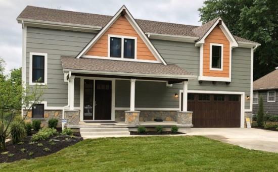 2807 W 50th Ter, Westwood, KS 66205 - view of front of home featuring a porch, concrete driveway, a garage, a front yard, and stone siding