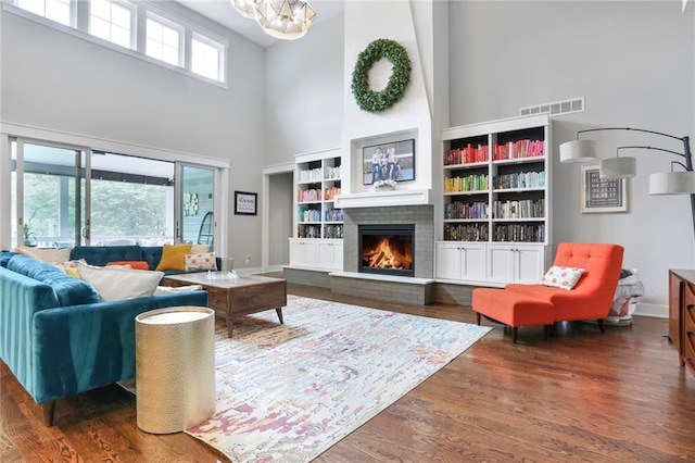 2807 W 50th Ter, Westwood, KS 66205 - living area with a towering ceiling, a fireplace, wood finished floors, baseboards, and a chandelier