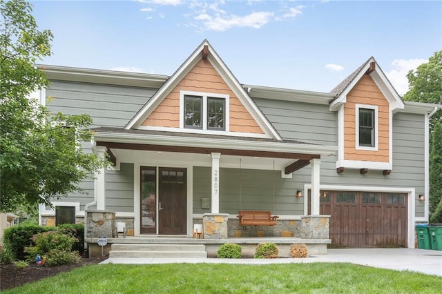 2807 W 50th Ter, Westwood, KS 66205 - craftsman-style house featuring a garage, a porch, concrete driveway, stone siding, and a front lawn