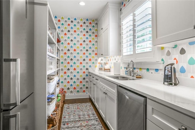 2807 W 50th Ter, Westwood, KS 66205 - kitchen with stainless steel appliances, a sink, wallpapered walls, white cabinetry, and recessed lighting