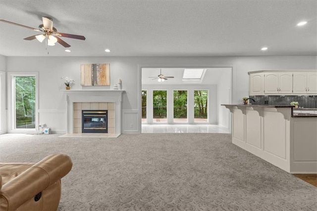 8407 W 141st St, Overland Park, KS 66223 - carpeted living area featuring a ceiling fan, a fireplace, recessed lighting, and a skylight
