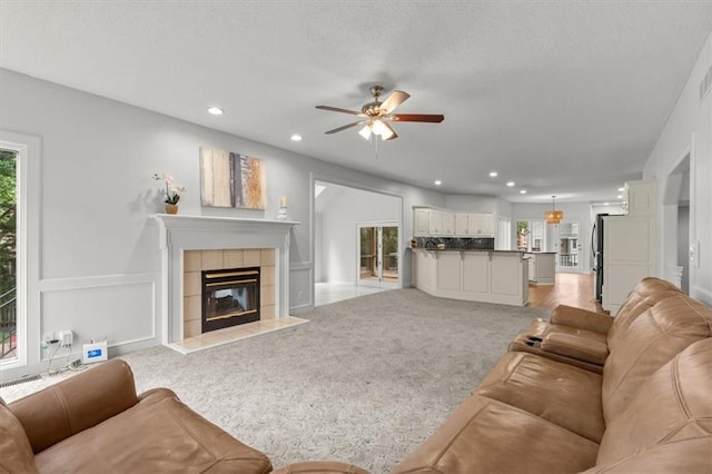 8407 W 141st St, Overland Park, KS 66223 - living area with ceiling fan, a tile fireplace, recessed lighting, light colored carpet, and a textured ceiling