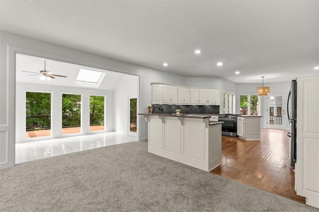 8407 W 141st St, Overland Park, KS 66223 - kitchen with appliances with stainless steel finishes, a peninsula, recessed lighting, a skylight, and open floor plan