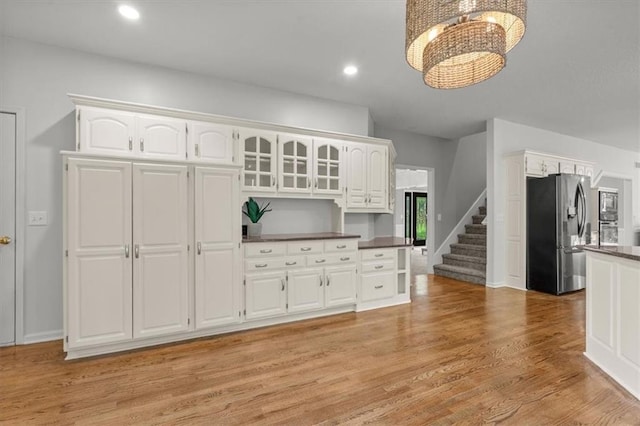 8407 W 141st St, Overland Park, KS 66223 - kitchen featuring stainless steel refrigerator with ice dispenser, dark countertops, a chandelier, white cabinetry, and light wood finished floors