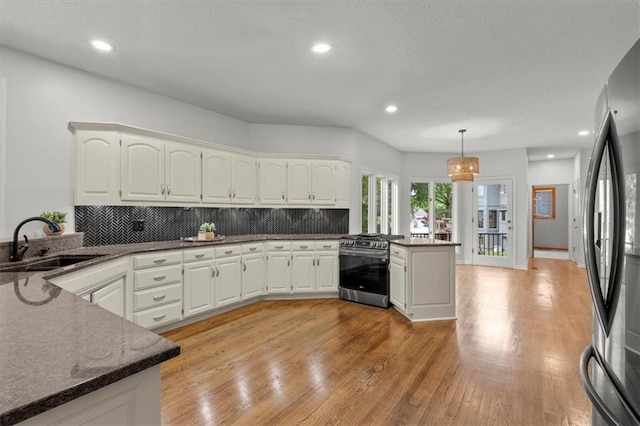 8407 W 141st St, Overland Park, KS 66223 - kitchen featuring a peninsula, appliances with stainless steel finishes, a sink, tasteful backsplash, and light wood-style floors