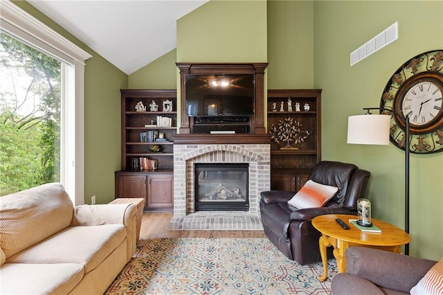 22614 W 46th Ter, Shawnee, KS 66226 - living area with vaulted ceiling, wood finished floors, and a fireplace