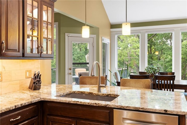 22614 W 46th Ter, Shawnee, KS 66226 - kitchen with a sink, light stone countertops, backsplash, dark brown cabinetry, and vaulted ceiling