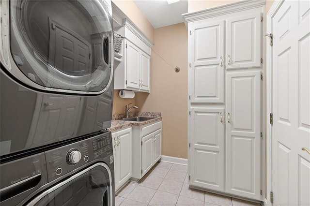 22614 W 46th Ter, Shawnee, KS 66226 - laundry area featuring stacked washing machine and dryer, cabinet space, light tile patterned floors, and baseboards