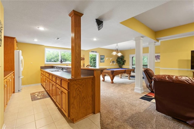22614 W 46th Ter, Shawnee, KS 66226 - kitchen featuring ornate columns, freestanding refrigerator, a sink, open floor plan, and brown cabinets